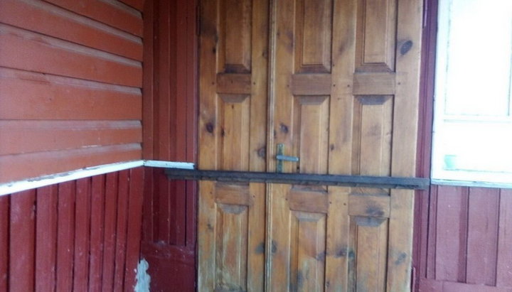 Activists of the OCU have barred the door to the house where the St. Michael community of the UOC performs Divine services with a metal rail.